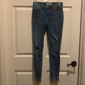 FREE PEOPLE medium wash distressed skinny jeans with fringe bottoms size 27”W